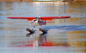 A Piper Cub on floats taking off from the river.